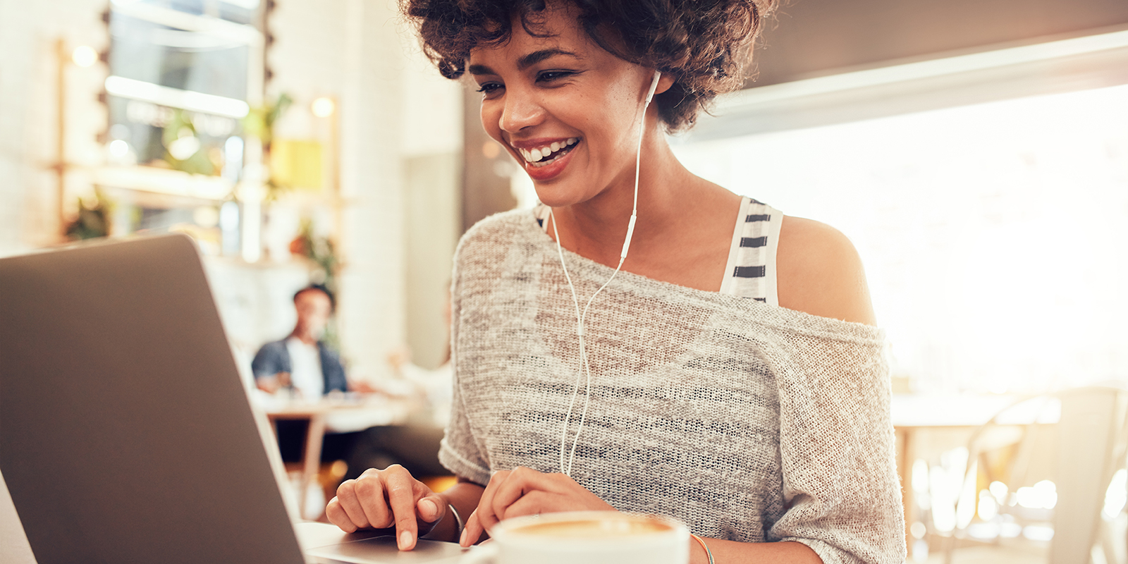 Beautiful girl smiling and typing on laptop looking for a good medical website design