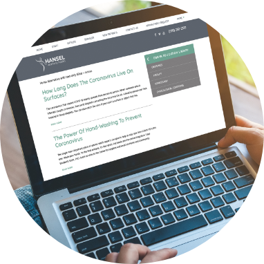 A person using a laptop displaying an ob gyn website design