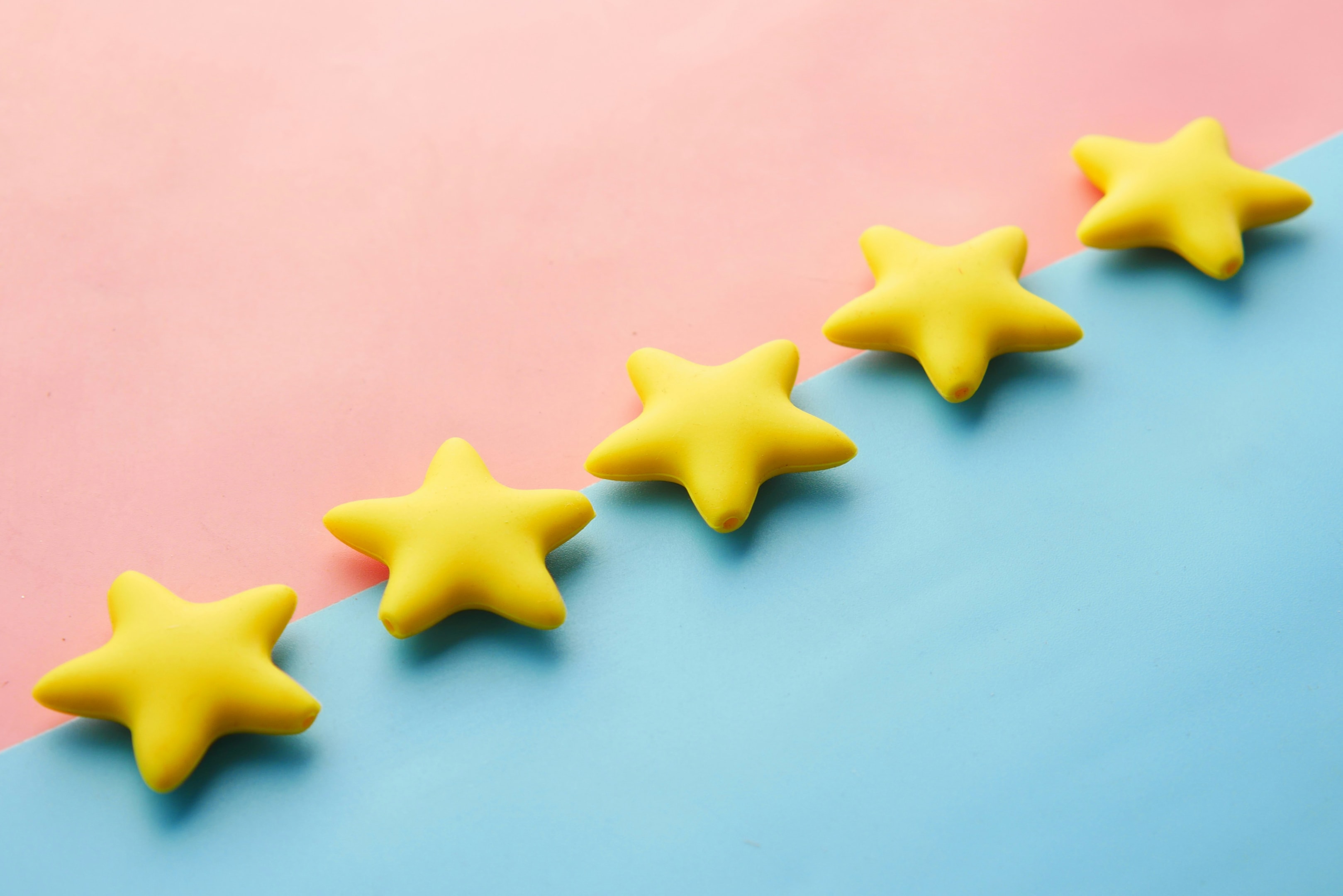 Five yellow star shaped objects on a pink and blue background symbolizing reputation management.